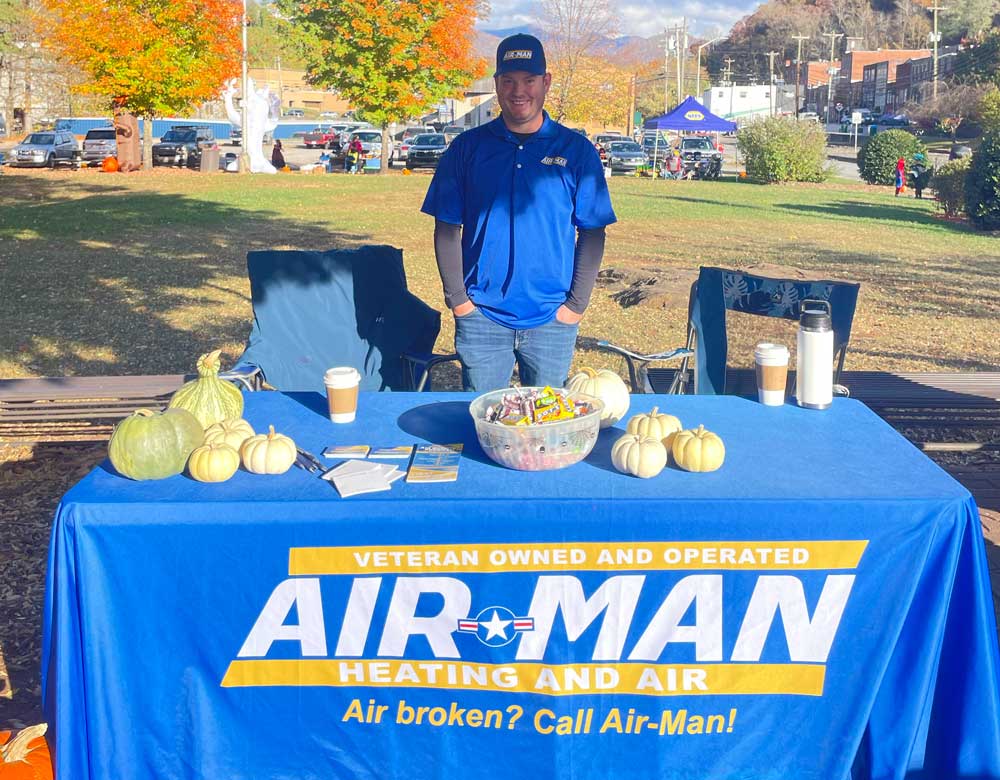 Air-Man Heating and Air team member at a community pumpkin patch event table