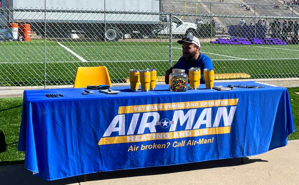 Air-Man Heating and Air sponsorship table at a football stadium